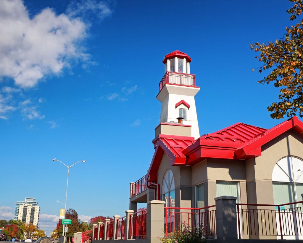 Port Credit Lighthouse in Mississauga during autumn with a clear blue sky overhead.